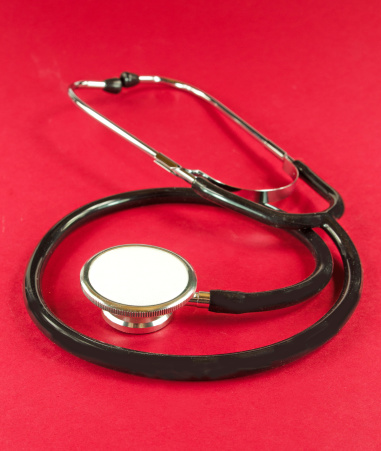 A stethoscope shaping a heart on a medical uniform, closeup, selective focus.