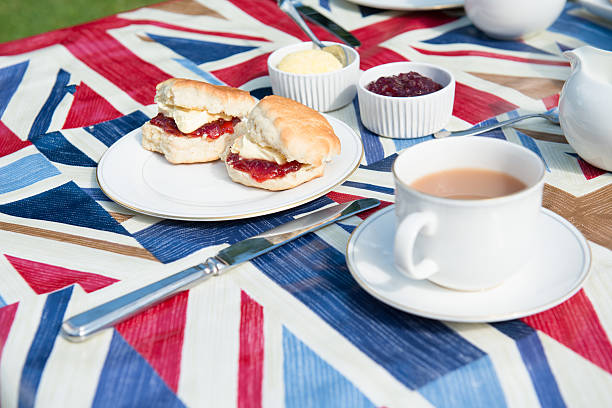 il tradizionale tè inglese sulla tovaglia patriottico - afternoon tea scone tea cream foto e immagini stock
