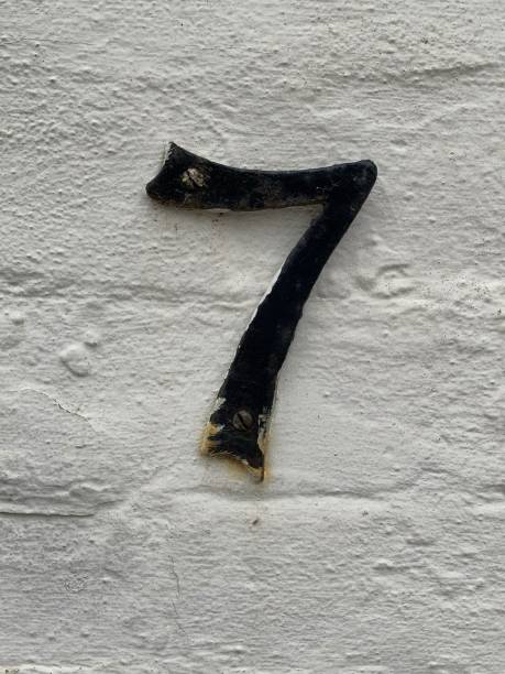 Number seven door sign attached to a white painted smooth rendered wall