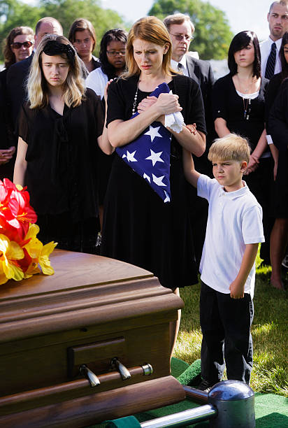 Family at a Funeral A mother and two children standing graveside at a funeral. child casket stock pictures, royalty-free photos & images