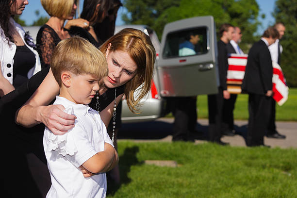Mother and Son at a Funeral A mother comforting her son at a military funeral. child casket stock pictures, royalty-free photos & images