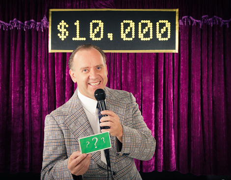 A retro color processed game show host holding a microphone. Photographed in studio with a purpose built set and props.