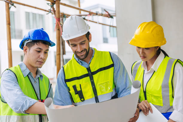 istock happy group of construction worker team working with architect and foreman talking consult project planning with floor plan 1731959370