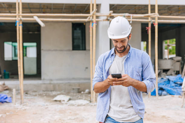 istock happy foreman builder using smart phone calling business contact in construction site. construction engineer or architect with modern connection technology device.real estate investor 1731969283