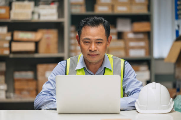 istock Senior engineer happy working with laptop computer for products inventory control manager. Asian adult male worker in factory store warehouse. 1731970362