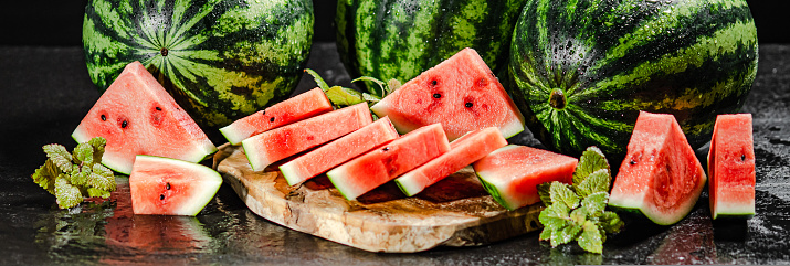 Sliced fresh watermelon. On a black background.