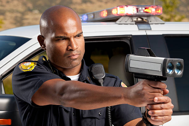 istock Police Officer checking vehicle speed with radar gun 173198007