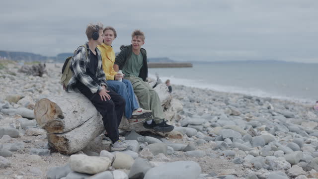 Teenagers enjoying Lyme Regis Fossil Beach in Dorset, United Kingdom