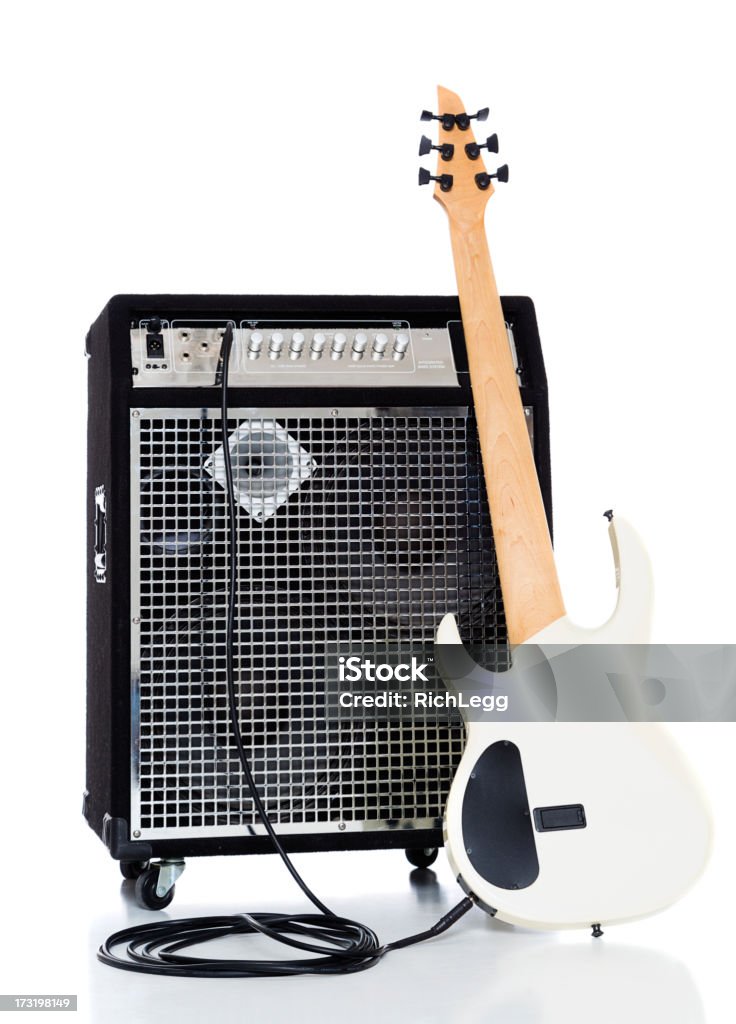 Bass Guitar and Amp A six string bass guitar leaning against an amplifier, isolated on a white background. Guitar Stock Photo