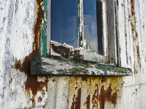 Window and frame on decaying boatyard structure in old town Provincetown, Cape Cod.