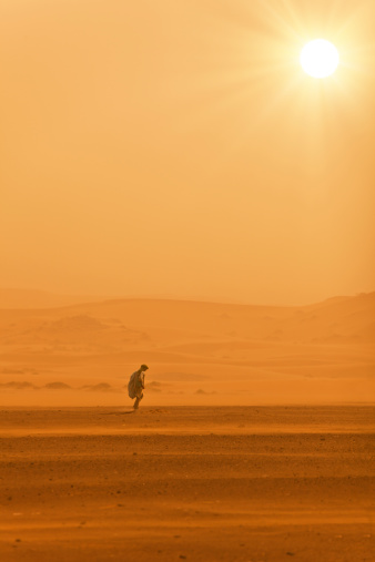 A man walks in the desert without water.