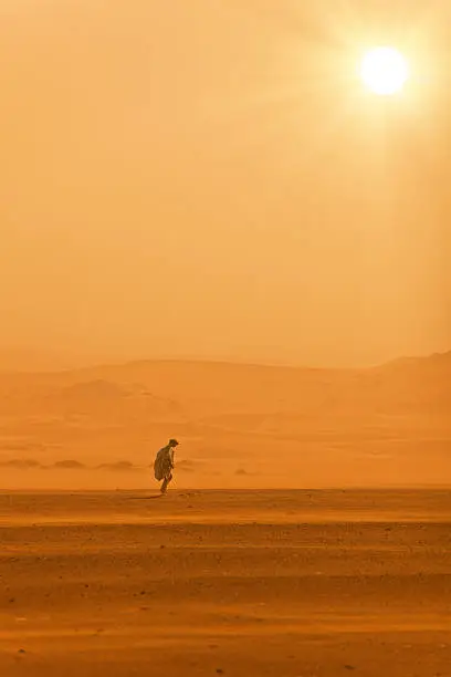 A man walks in the desert without water.