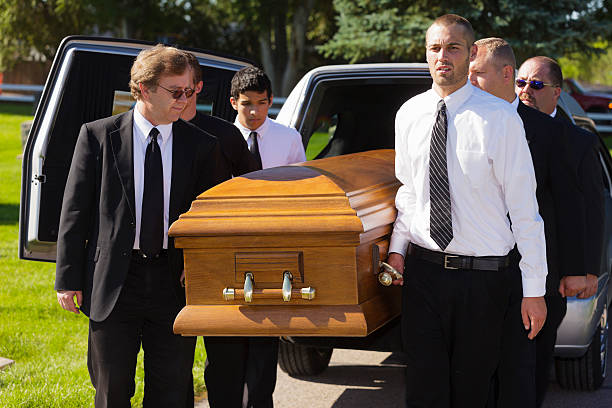 Funeral Pallbearers A group of men carrying a casket in a funeral. funeral parlor photos stock pictures, royalty-free photos & images