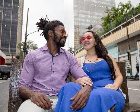 Japanese woman and black man dating and having fun in the street. Multiethnic brazilian couple.