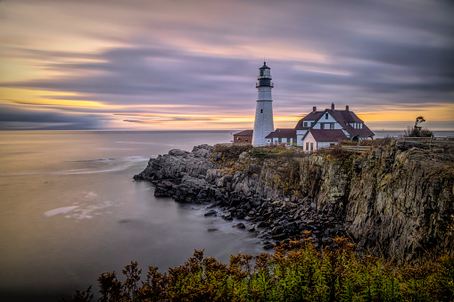 Golden sunset light hitting the side of a tall stone lighthouse. Montauk Point, New York