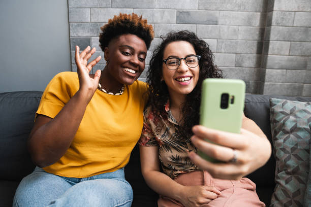 istock lesbian couple make video call and wave 1731990519