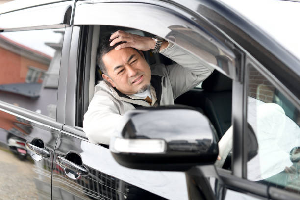 istock Middle-aged Asian man driving a car with an anxious expression 1732001887