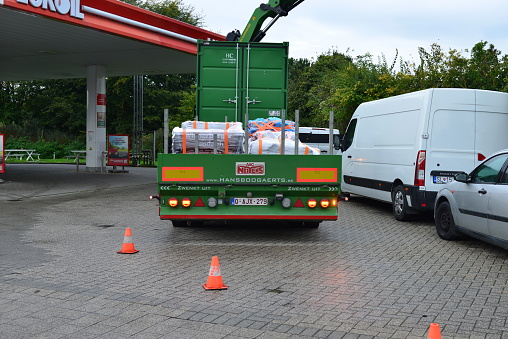 Leuven, Flemish-Brabant, Belgium - October 12, 2023: truck loaded with natural black roof tiles is lifting them up to the top of the roof