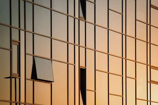 Glass facade of a modern office building at sunset