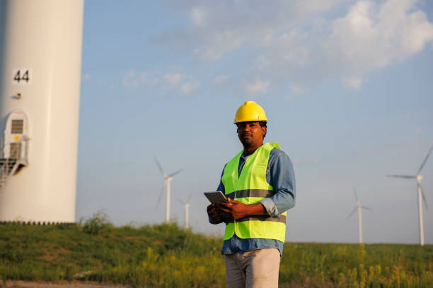 istock Young Engineer wearing uniform ,helmet hold document inspection work in wind turbine farms rotation to generate electricity energy. 1732010774