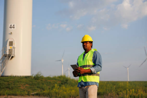 istock Young Engineer wearing uniform ,helmet hold document inspection work in wind turbine farms rotation to generate electricity energy. 1732010789