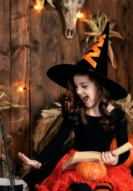 istock girl in a witch costume casts a spell on Halloween 1732012395
