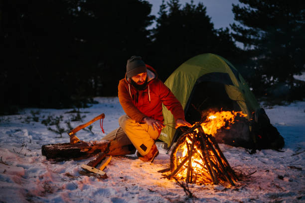 istock A man sits near a campfire, warming himself by the fire in a winter forest at sunset. 1732016358