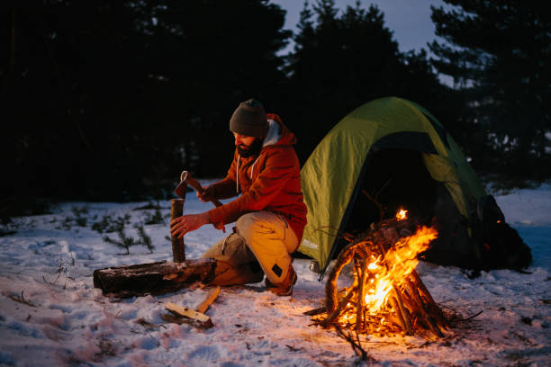 istock A tourist chops wood for a bonfire in a winter forest at night. 1732016367