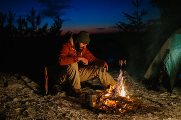 istock A bearded young man makes delicious coffee on a bonfire while enjoying the sunset in a winter forest. The concept of survival and hiking in the wild. 1732017444