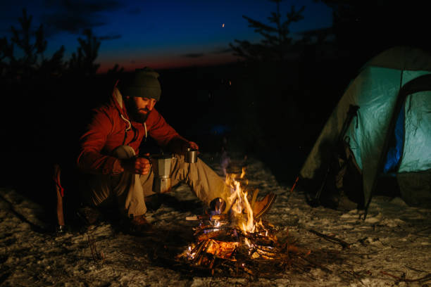 istock A bearded young man makes delicious coffee on a bonfire while enjoying the sunset in a winter forest. The concept of survival and hiking in the wild. 1732017446
