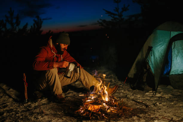 istock A bearded young man makes delicious coffee on a bonfire while enjoying the sunset in a winter forest. The concept of survival and hiking in the wild. 1732017448