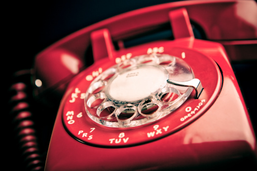 Moody red retro phone on a deep toned background.