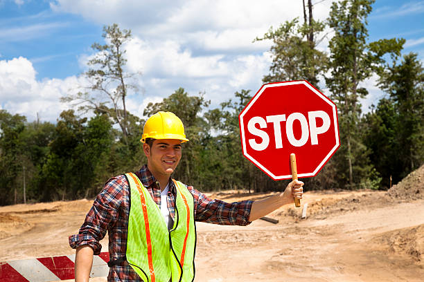 istock Road construction flagman.  He holds a stop sign. 173203729