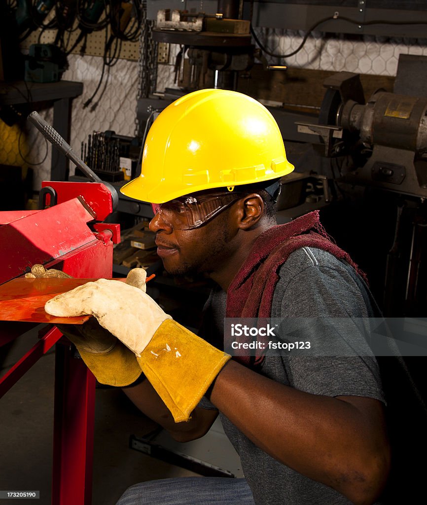 Workman usando capacete de segurança, óculos de proteção e luvas do workshop - Foto de stock de Curvar-se royalty-free