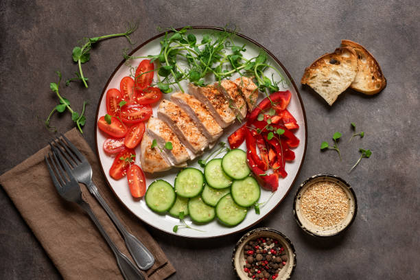 istock Grilled chicken fillet close-up with fresh vegetables on a dark rustic background. Top view, flat lay 1732053245