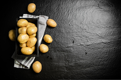 Fresh potatoes. On a black background.