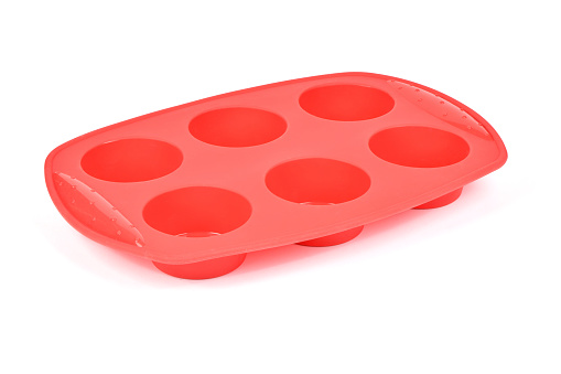 Red silicone form for cooking muffin and cupcake on white background. Side view. High resolution photo. Full depth of field.