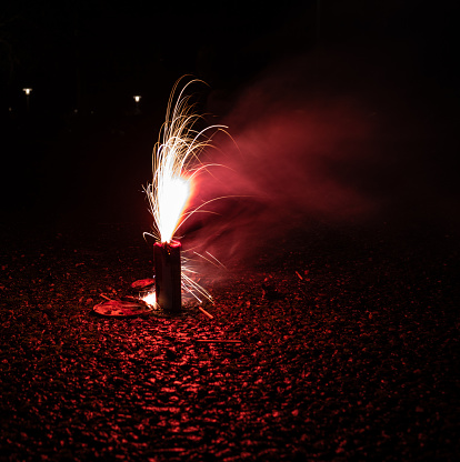Red ground fireworks on asphalt.