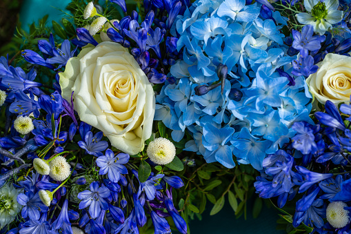 Blue and white flowers of a funeral wreath.