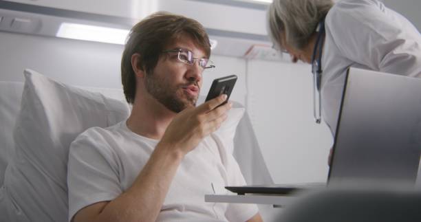 istock Man lies on bed and chats using phone in hospital 1732073044