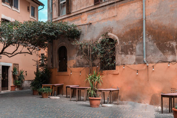istock wall of a building with potted plants. Charming facade with shutters. Paved sidewalk 1732076056