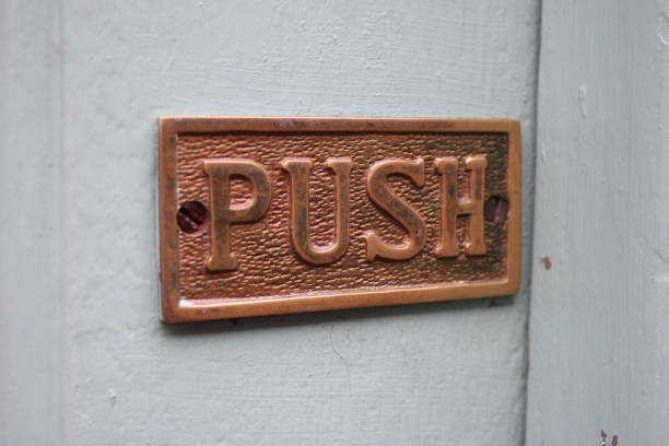 istock Worn bronze push sign on a external door 1732080424
