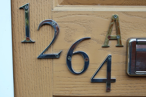 House numbers 1264 A attached to brown door Up close perspective UK