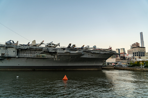 A view of Pearl Harbor, Hawaii, from the back of a navy launch docked at the U.S.S. Arizona memorial. The American flag is at the rear of the launch; in the distance on the right is the U.S.S. Missouri, on which the surrender of Japan was signed in 1945.