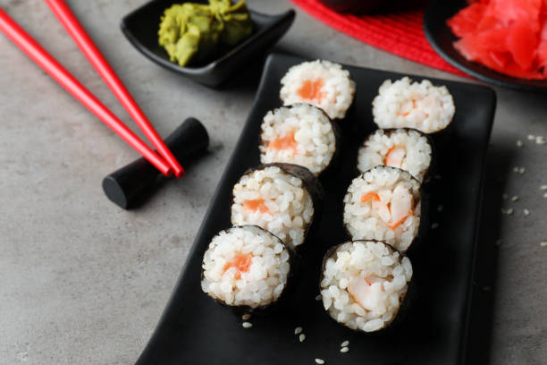 istock Tasty sushi rolls served on grey table 1732100755