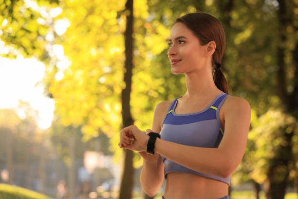 istock Attractive happy woman checking pulse after training in park on sunny day. Space for text 1732129368