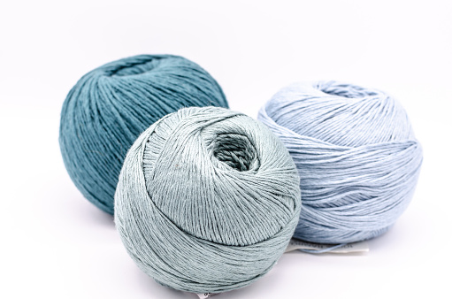 Three yarns of wool in blue colors with white background