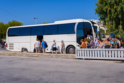 Naousa, GR - 2 August 2023: People boarding the city bus on Paros Island