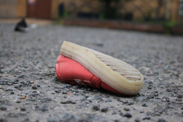 istock Discarded children's pink shoe upside down in a public space 1732184656