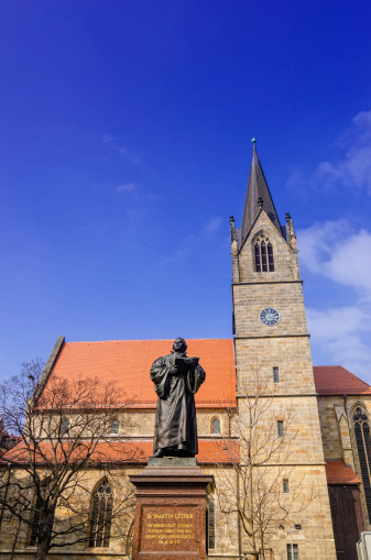 The monument of Martin Luther in front of the Kaufmannskirche in the center of Erfurt, displays Dr. Martin Luther holding an open bible in his left hand.